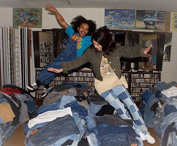 Friends jumping into a pile of vintage jeans at Drop Your Jeans